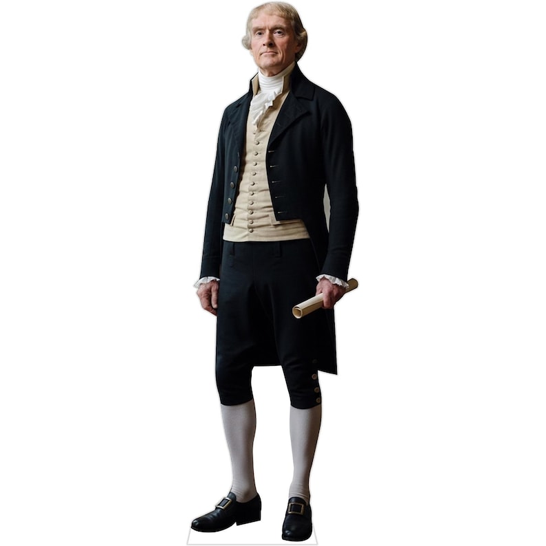 May include: A life-sized cardboard cutout of Thomas Jefferson wearing an 18th-century black tailcoat, a beige waistcoat with silver buttons, a white ruffled cravat, knee-length black breeches, white stockings, and black buckled shoes, holding a scroll.