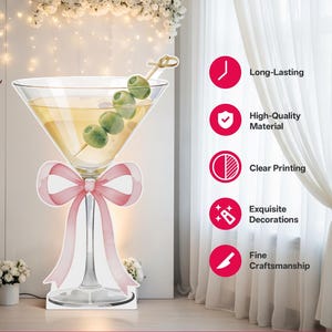 May include: A large, flat, die-cut cardboard cutout of a martini glass filled with a pale yellow liquid and a skewer of four green olives. A soft pink ribbon is tied around the stem of the glass. The text Long-Lasting, High-Quality Material, Clear Printing, Exquisite Decorations, and Fine Craftsmanship appears in a vertical list on the right side.