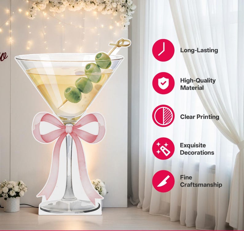 May include: A large, flat, die-cut cardboard cutout of a martini glass filled with a pale yellow liquid and a skewer of four green olives. A soft pink ribbon is tied around the stem of the glass. The text Long-Lasting, High-Quality Material, Clear Printing, Exquisite Decorations, and Fine Craftsmanship appears in a vertical list on the right side.