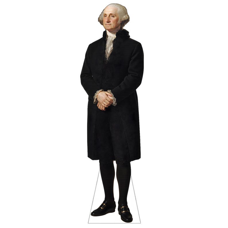 May include: A life-sized cardboard cutout of George Washington standing in a formal pose. He wears a long black coat, black breeches, black stockings, and black shoes with buckles. A white ruffled cravat is visible at the neck and cuffs.