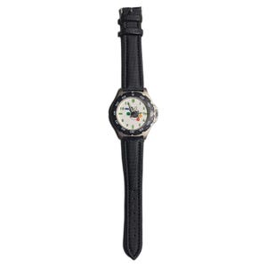 Pode incluir: Um relógio de pulso com uma bracelete preta texturizada e uma caixa prateada. O mostrador branco apresenta numerais pretos, uma luneta rotativa preta com marcas brancas e um design gráfico central com pequenos círculos coloridos e o texto "Cineplex".