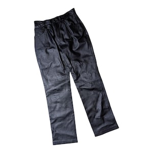 May include: Black leather pants with a classic five-pocket design. The pants have a straight leg cut and a slightly textured appearance. The leather appears to be a matte finish, and the pants are shown against a white background.