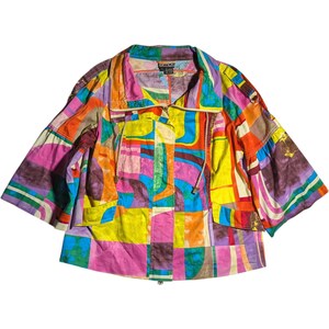 Könnte beinhalten: Bunte Jacke mit kurzen Ärmeln und Patchwork-Design. Die Jacke hat einen Reißverschluss, einen Kordelzug in der Taille und eine Vielzahl von Farben, darunter Rosa, Gelb, Orange und Blau. Die Jacke hat einen Kragen und zwei Vordertaschen.