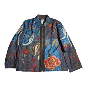 May include: A denim jacket with a floral embroidered design. The jacket features a zipper closure and a collared neckline. The embroidery includes red, orange, and white flowers with green leaves, set against a blue and denim background.