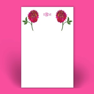 May include: White stationery with a pink floral design and the monogram "EBM" at the top.