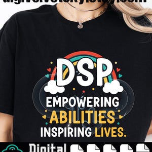 May include: Black t-shirt featuring a colourful graphic design. The design includes the letters "DSP" above the words "Empowering Abilities Inspiring Lives" with a rainbow and cloud motif. The words "Digital download" are also present.