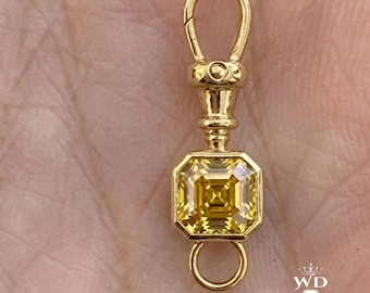 May include: A gold-toned metal jewelry clasp featuring a square-cut yellow gemstone set in the center. The component includes a swivel lobster claw mechanism at the top and a small circular jump ring at the bottom, with a polished metallic finish.