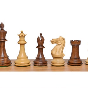 Könnte beinhalten: Ein Satz hölzerner Schachfiguren, darunter König, Dame, Läufer, Springer, Turm und Bauer. Die Figuren sind aus dunkelbraunem und hellbraunem Holz gefertigt und in einer Reihe auf einer Holzoberfläche angeordnet.