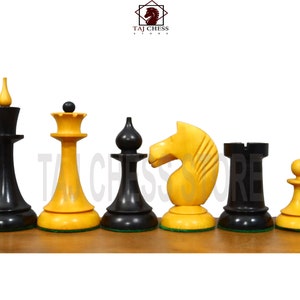 May include: A set of chess pieces in black and yellow wood. The pieces include a king, queen, bishop, knight, rook, and pawn. The pieces are arranged in a row on a wooden surface.