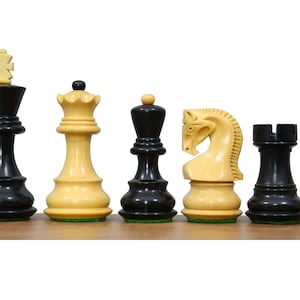 May include: A set of chess pieces, including a king, queen, bishop, knight, rook, and pawn. The pieces are made of wood and are painted in black and white.