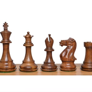 Op de afbeelding: Een set van zes houten schaakstukken, waaronder een koning, een koningin, een loper, een paard en een toren. De stukken zijn allemaal gemaakt van donkerbruin hout en hebben een traditioneel ontwerp.