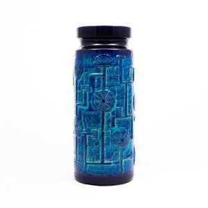 May include: A blue ceramic vase with a geometric pattern. The vase has a wide mouth and a narrow base.