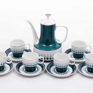 Puede incluir: Un juego de té vintage con un patrón floral verde y blanco. El juego incluye una tetera y seis tazas y platillos.