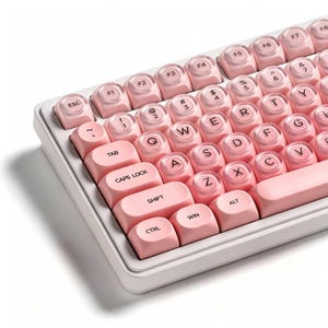 Könnte beinhalten: Eine Computertastatur mit weißem Rahmen und hellrosa Tasten. Die Tasten haben ein abgerundetes Schreibmaschinen-Design mit klaren, kreisförmigen Zentren, die schwarze Buchstaben, Zahlen und Funktionsbeschriftungen wie ESC, TAB, CAPS LOCK, SHIFT, CTRL, WIN und ALT zeigen.