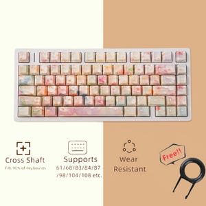 May include: White mechanical keyboard with floral keycaps. The keycaps feature a watercolor design with pink, orange, and blue hues. The keyboard supports various sizes and is wear-resistant. Includes a keycap puller.