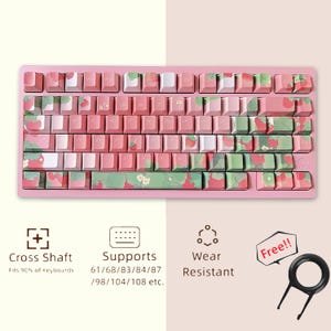 May include: Pink keyboard keycaps with a strawberry and floral design. The keycaps are compatible with 61, 68, 83, 84, 87, 98, 104, and 108 key keyboards. The keycaps are wear resistant and come with a keycap puller.