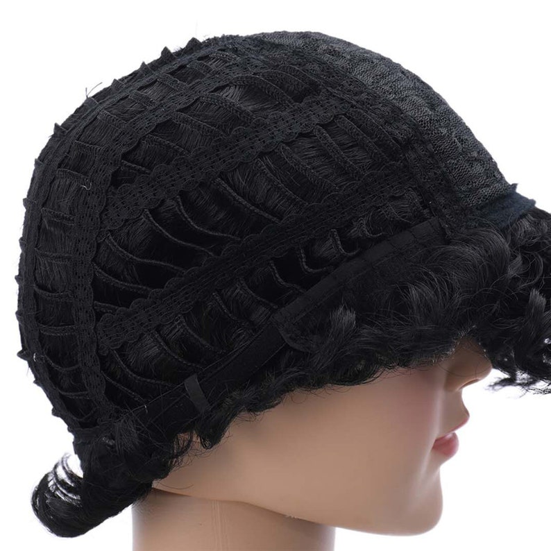 May include: Black wig with a lace front and adjustable straps. The wig has a short, curly style.