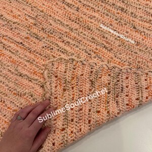 かぎ針編みのオレンジの斑点模様のベビーブランケット