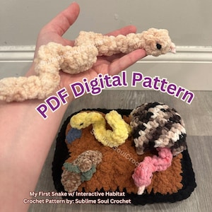 May include: A crochet pattern for a snake with an interactive habitat. The pattern includes instructions for making a snake, a log, a mushroom, a flower, and a turtle shell. The pattern is available as a digital download.