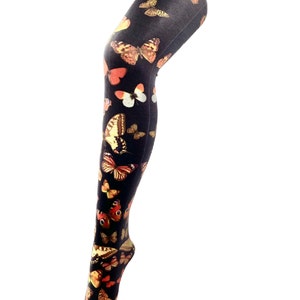 May include: Black tights with a colorful butterfly print. The butterflies are in various shades of orange, yellow, and brown.