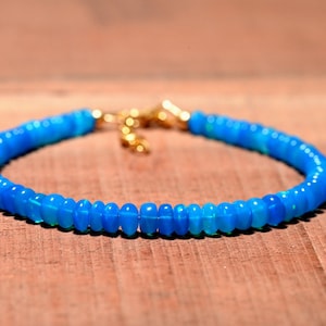 May include: A blue opal beaded bracelet with a gold clasp.