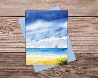 May include: A watercolor painting of a seascape with a sailboat on the horizon. The sky is a deep blue with white clouds, and the water is a light blue. The beach is a yellow sand with green grass.