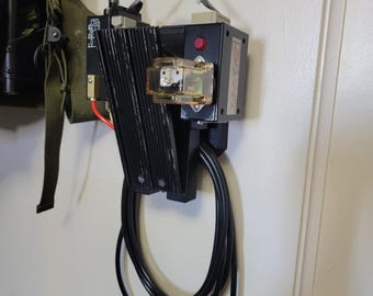 May include: A black wall-mounted air compressor with a red button and a clear plastic air filter. The compressor has two black hoses attached to it.