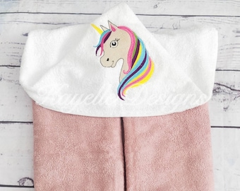 May include: White hooded towel with a pink towel underneath. The hood has an embroidered unicorn with a rainbow mane.