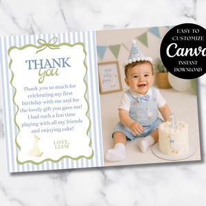 May include: A baby's first birthday thank you card with a photo of the baby. The card has a blue and white striped border and a message that says "Thank you." The photo shows the baby with a cake.