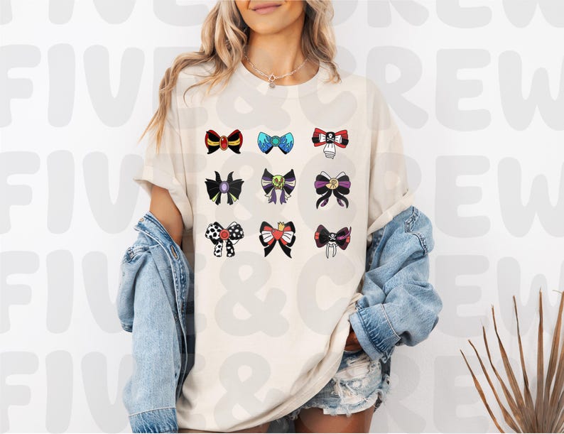 Op de afbeelding: Cr&egrave;mekleurig T-shirt met een verzameling kleurrijke strikdesigns. De strikken vari&euml;ren in stijl en kleur, waaronder zwart, rood, blauw en paars. Op het shirt staat de tekst "FIVE & CREW".