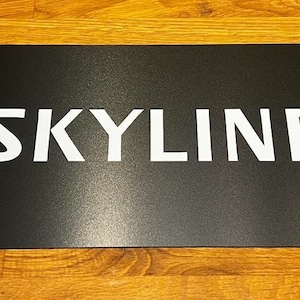 May include: Black rectangular sign with the word "SKYLINE" printed in white.
