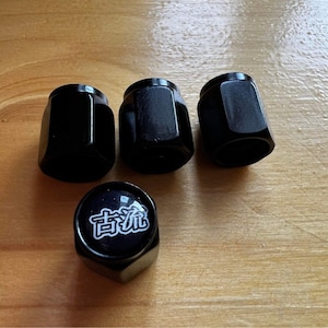 May include: Four black tire valve stem caps, one with white text that reads "古流".