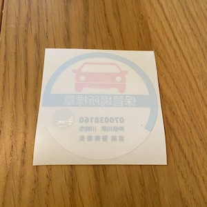 以下が含まれることがあります： 青い円の中にピンクの車のシルエットが入った白いステッカー。円の中に黒い文字で「車両用登録済」と書いてある。円の真下に黒い文字で「070038160」と書いてある。数字の下に黒い文字で「市制施行」と書いてある。「市制施行」の下に黒い文字で「愛知県豊田市」と書いてある。