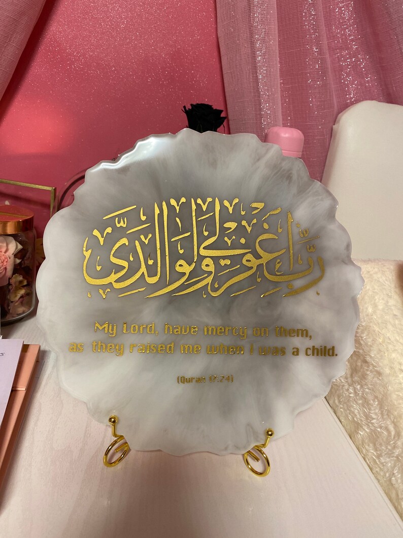 May include: A white resin plaque with a gold Arabic calligraphy design and the text "My Lord, have mercy on them, as they raised me when I was a child. (Quran 87:74)"