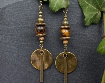 May include: A pair of gold tone earrings with tiger's eye beads and large round disc pendants.