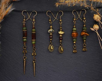 May include: A set of six long dangle earrings with a bohemian style. The earrings feature a variety of natural materials, including green and brown beads, and metal accents.