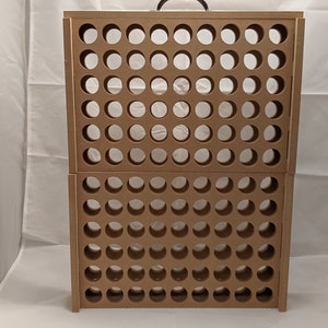 Puede incluir: Un estante de almacenamiento de madera marr&oacute;n con un asa en la parte superior. El estante tiene una cuadr&iacute;cula de agujeros redondos para guardar objetos.