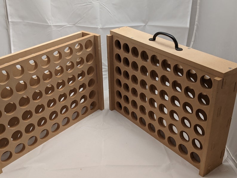 Puede incluir: Una caja de almacenamiento de madera con una manija negra y una cuadr&iacute;cula de agujeros redondos. La caja est&aacute; hecha de madera marr&oacute;n claro y est&aacute; abierta para revelar los agujeros.
