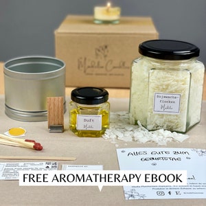 Puede incluir: Un kit para hacer velas con varios componentes, incluyendo una lata plateada, soportes de mecha de madera, cerillas y un pequeño frasco etiquetado "Duft". Un frasco más grande contiene copos de cera de soja. Incluye una tarjeta con "Alles Gute zum Geburtstag".