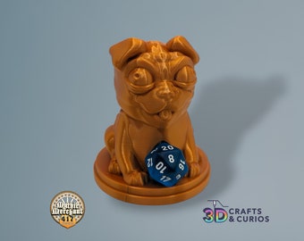 May include: A gold-colored 3D printed pug figurine holding a blue 20-sided dice. The pug has a playful expression with its tongue sticking out.