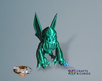 May include: A green 3D printed gargoyle figurine with wings and a toothy grin. The figurine is standing on a gray surface. The text "The Level-Up" and "Merchant Number 7215" is visible in the lower left corner of the image. The text "3D Crafts & Curios" is visible in the lower right corner of the image.