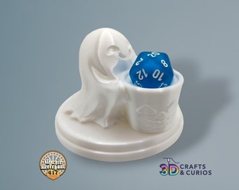 May include: White 3D printed ghost holding a blue 20-sided die in a pumpkin-shaped bucket. The base of the figurine is a round disc with the words "3D Crafts & Curios" printed on it.