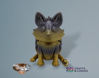 May include: A 3D printed figurine of a fox, sitting with its tail curled around its legs. The fox is painted in a gradient of gold and purple, with a black and white dice beside it. The figurine is labeled "The Level-Up Merchant Number 7215".