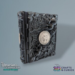 May include: A black, intricately detailed book with a silver spider and a silver face with a tongue sticking out. The book is titled "The Librarian's Enchanted Tome" and "Licensed Merchant".
