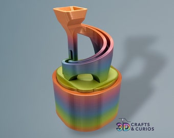 May include: A 3D printed rainbow-colored sculpture with a funnel-shaped top and a curved track. The sculpture is made of multiple layers of plastic, each with a different color. The sculpture is on a base with a rainbow-colored pattern.