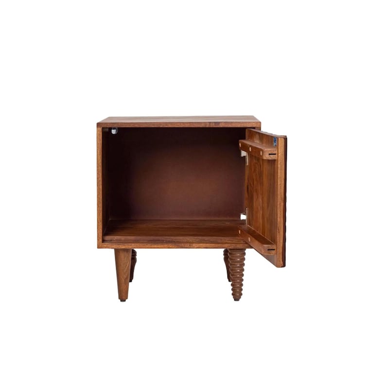 Pu&ograve; includere: Un comodino in legno marrone scuro con una singola porta aperta. Il comodino ha una forma rettangolare e quattro gambe, di cui due tornite e decorative. Anche l'interno &egrave; marrone.