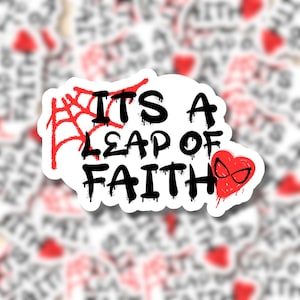 May include: White sticker with black text that reads "It's a Leap of Faith" with a red spiderweb and a red heart with a black spider-man mask in the corner.