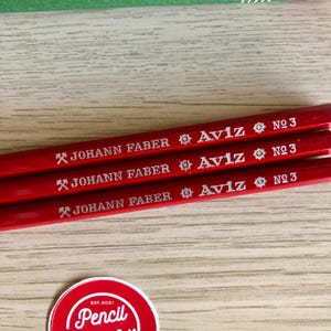 Może przedstawiać: Trzy czerwone oł&oacute;wki z srebrnym napisem. Oł&oacute;wki są oznaczone "JOHANN FABER Aviz N№ 3".