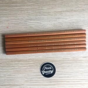 K&ouml;nnte beinhalten: Ein Satz von acht braunen Holzstiften mit goldener Beschriftung. Die Stifte sind mit "Johann Sindel Class Extra" und "Gebro No. 2" beschriftet.