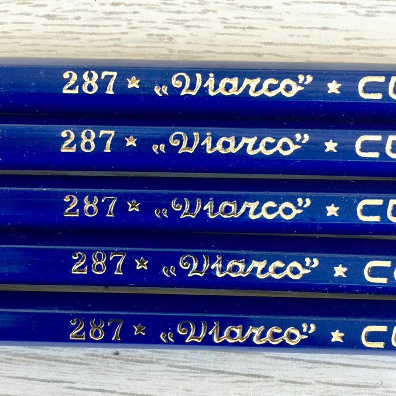Puede incluir: Primer plano de cinco l&aacute;pices azules con letras doradas. Cada l&aacute;piz tiene el n&uacute;mero "287" y el texto "&laquo;Viarco&raquo; * CO" impreso en &eacute;l.